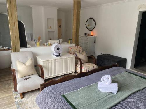 1 Schlafzimmer mit einem Bett, 2 Stühlen und einem Waschbecken in der Unterkunft Lovely Family Home in Pecanwood Golf Estate in Kosmos