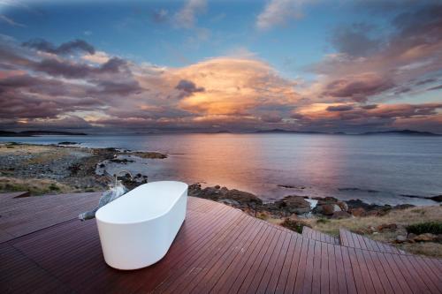 a white bucket sitting on a table near the water at Thalia Haven in Little Swanport
