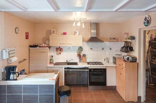 une cuisine avec un évier et une cuisinière dans l'établissement Maison familiale accueillante à Longvilliers avec grand jardin, à Longvilliers