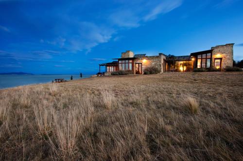 an old house on top of a field at night at Thalia Haven in Little Swanport