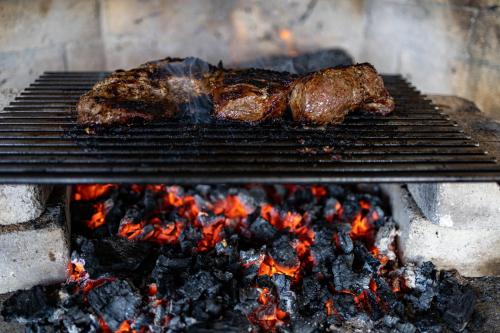 two pieces of meat are cooking on a grill at Thalia Haven in Little Swanport