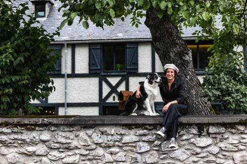 a man and a dog sitting next to a tree at La Sainthilarienne in Saint-Lary-Soulan