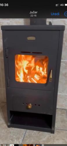 a black stove with a fire inside of it at Racina Apartmani in Plav