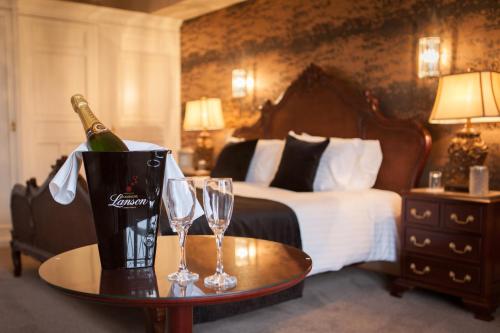a hotel room with a bottle of champagne and two glasses at Inglewood House and Spa in Alloa