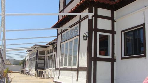 a house with a porch and a patio at Hotel Chalet Suizo in Viña del Mar