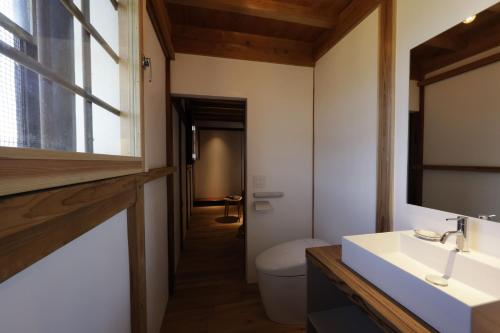 a bathroom with a toilet and a sink and a window at Satoyama Jujo The House in Minami Uonuma