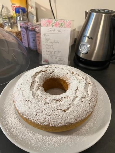 a powdered donut sitting on a plate on a table at Sonila's Home 1 in Bergamo