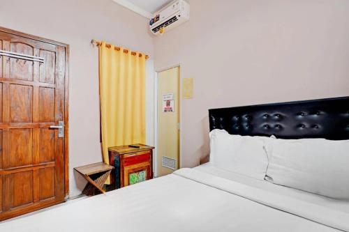 a bedroom with a bed and a wooden door at Kediri Homes Guest House in Kediri
