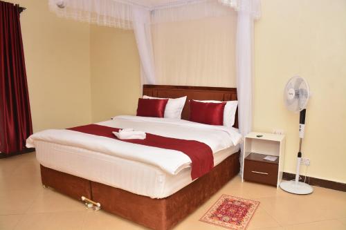 a bedroom with a large bed with red pillows at Kaizen Residences in Entebbe