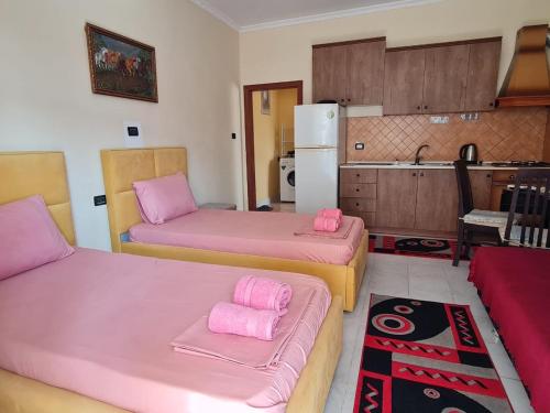 a kitchen with two beds with pink sheets at Veri's house in Tirana