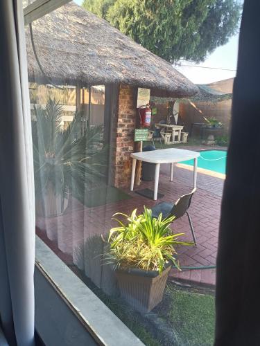 a view of a patio with a table and a pool at Ay Jay's Guesthouse in Bloemfontein