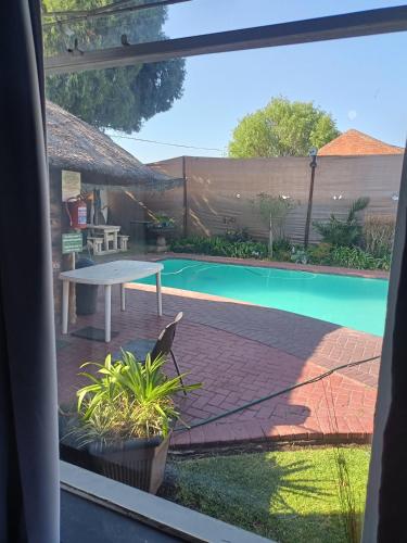 a view of a swimming pool from a window at Ay Jay's Guesthouse in Bloemfontein
