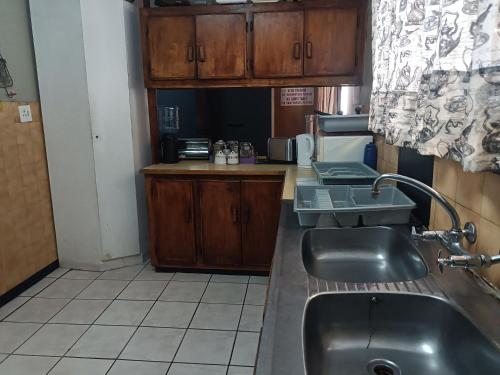 a kitchen with a sink and a counter top at Ay Jay's Guesthouse in Bloemfontein
