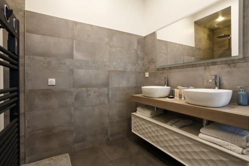 une salle de bain avec deux lavabos et deux miroirs dans l'établissement Renovated spacious Parisian apt near la Madeleine, à Paris