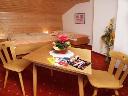 ヴァークラインにあるHaus Lärchenheimのテーブルとベッド2台が備わる小さな客室です。