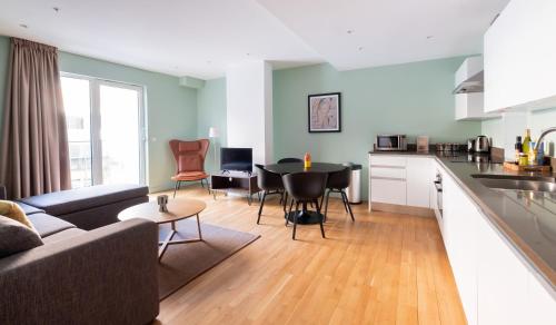 a kitchen and living room with a couch and a table at Native Victoria in London