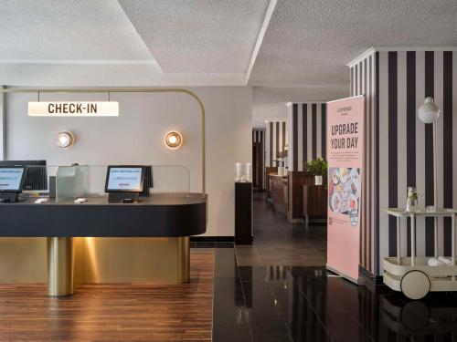 a lobby with a check in counter in a store at Flemings Hotel Frankfurt Main-Riverside in Frankfurt/Main