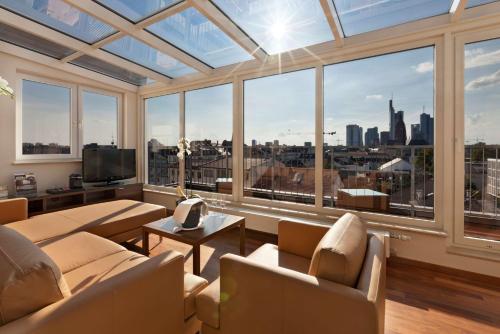 a living room with a view of a city at Flemings Hotel Frankfurt Main-Riverside in Frankfurt/Main