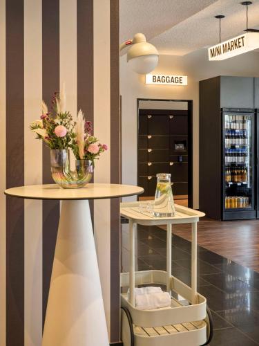 a vase of flowers on a table in a store at Flemings Hotel Frankfurt Main-Riverside in Frankfurt/Main