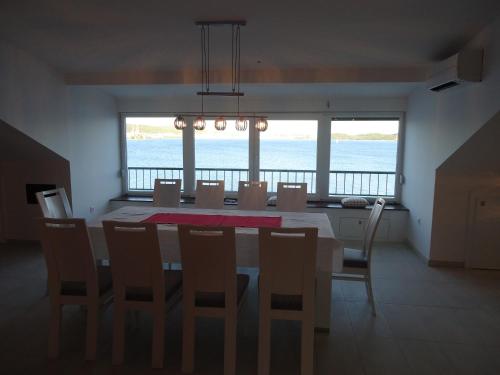 una sala da pranzo con tavolo, sedie e vista sull'oceano di Holiday Home Sisko a Trogir