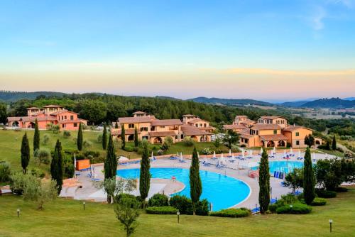 an aerial view of a resort with a large swimming pool at Residence with swimming pool immersed in the typical Tuscan countryside just 5 minutes from Massa Marittima in Podere Pian Mucini