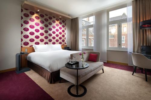 a hotel room with a bed and a chair at Sofitel Legend The Grand Amsterdam in Amsterdam