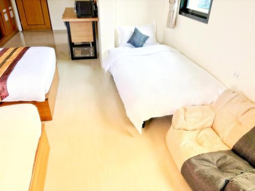 a room with a bed and a couch in it at patong v hotel in Patong Beach