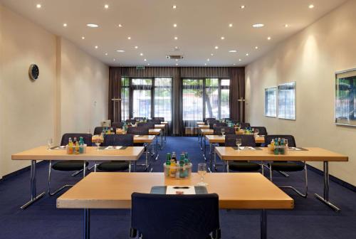 a dining room with tables and chairs in a building at Flemings Hotel München-Schwabing in Munich
