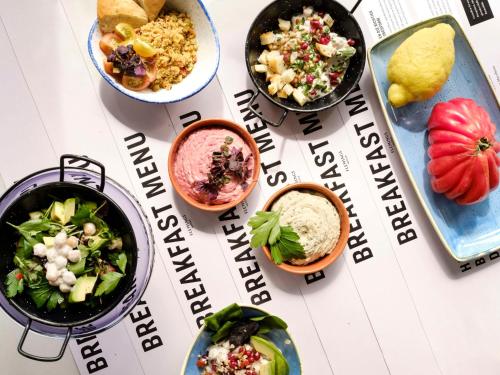 a table with bowls of food on a menu at Flemings Hotel München-Schwabing in Munich