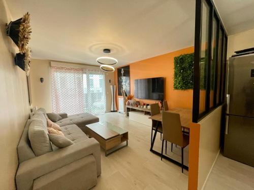 a living room with a couch and a table at Appartement Cosy in Saint-Gratien