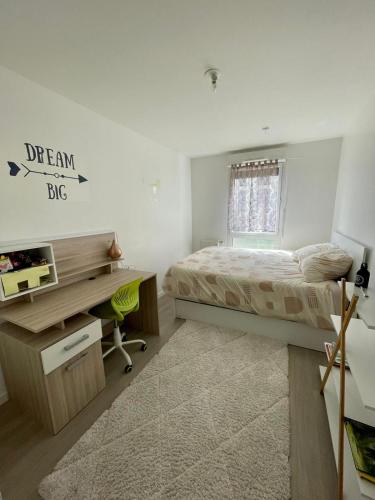 - une chambre avec un lit et un bureau dans l'établissement Appartement Cosy, à Saint-Gratien