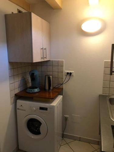 une cuisine avec une machine à laver dans une pièce dans l'établissement Studio de charme à Niederbronn-les-Bains, à Niederbronn-les-Bains
