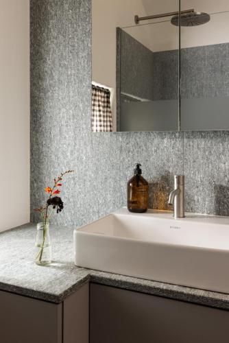a bathroom with a white sink and a mirror at Hotel Chesa Rosatsch - Home of Food in Celerina