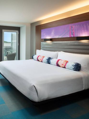 a large white bed in a hotel room at Aloft San Francisco Airport in Millbrae