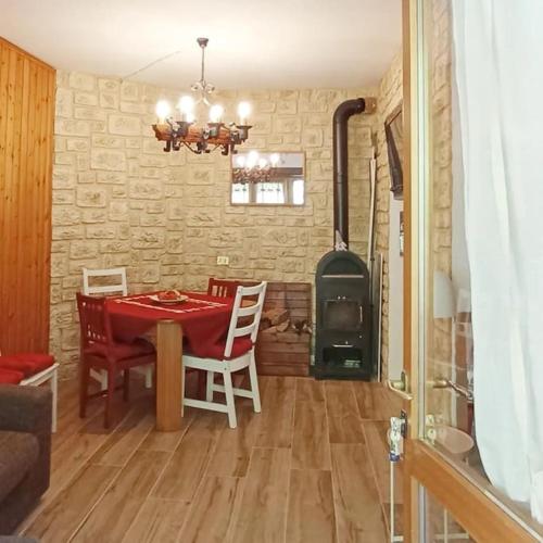 a dining room with a table and a stove at ALLA CASCATA in centro Branzi self check-in parcheggio gratuito coperto in Branzi
