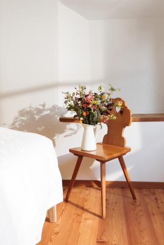a table with a vase of flowers on it at Hotel Chesa Rosatsch - Home of Food in Celerina