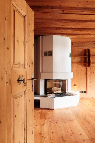 a kitchen with a stove in a wooden room at Hotel Chesa Rosatsch - Home of Food in Celerina