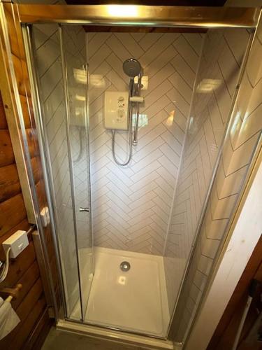 a shower with a glass door in a bathroom at Gwel-y-Cwm - Valley View in Trawsfynydd