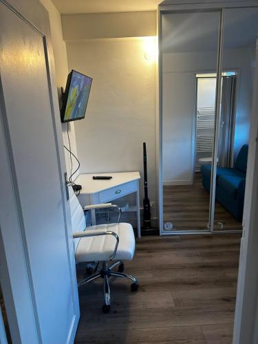 une pièce avec un bureau, une chaise et un miroir dans l'établissement L'ancre marine, à Berck-sur-Mer
