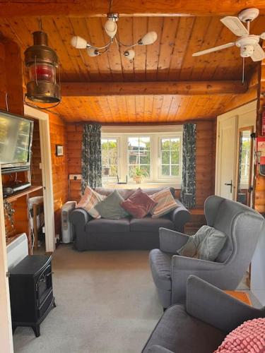 a living room with couches and a flat screen tv at Gwel-y-Cwm - Valley View in Trawsfynydd