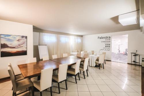a conference room with a wooden table and chairs at Hotel Globo in Formigine