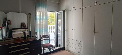 a room with white cabinets and a mirror and a chair at CHRYSA' S House in Volos