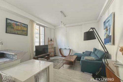 un salon avec un canapé bleu et une télévision dans l'établissement Flexliving - T2 - Servan, à Paris