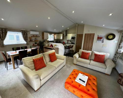 a living room with two couches and a kitchen at Meadows 50 - Southview Holiday Park Skegness in Skegness
