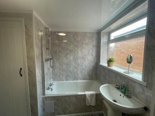 a bathroom with a bath tub and a sink at Imeary -3 Bdrm Sleeps 5 Contractor Accommodation in Westoe