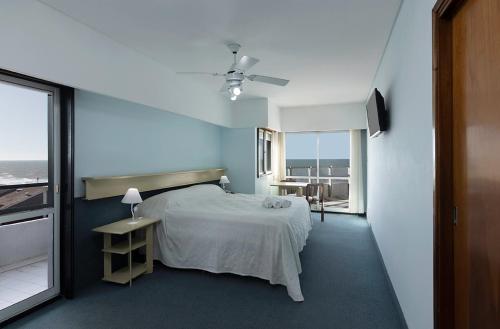 1 dormitorio con cama y vistas al océano en el Hotel Coliseo en Villa Gesell