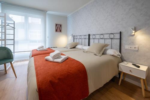 a bedroom with two beds with towels on them at TERRA de Padrón - Quality Rooms in Padrón