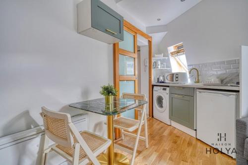 une cuisine avec une table et des chaises dans une pièce dans l'établissement Le Mignon - Proche Haussman - 289B, à Paris