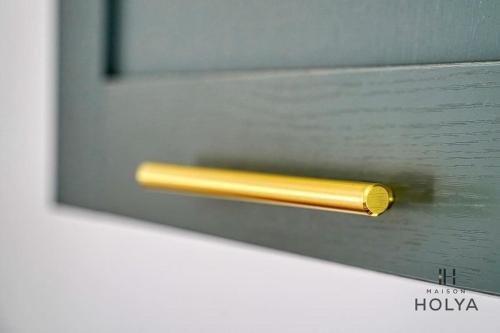 une poignée de porte en or sur une porte en verre dans l'établissement Le Mignon - Proche Haussman - 289B, à Paris