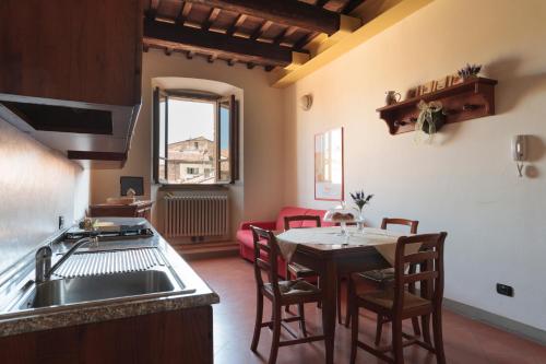 eine Küche und ein Esszimmer mit einem Tisch und Stühlen in der Unterkunft Residenza Antica Canonica in Città di Castello